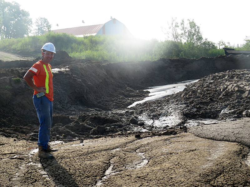 Aecon Case Worker Operator standing on solidified mud